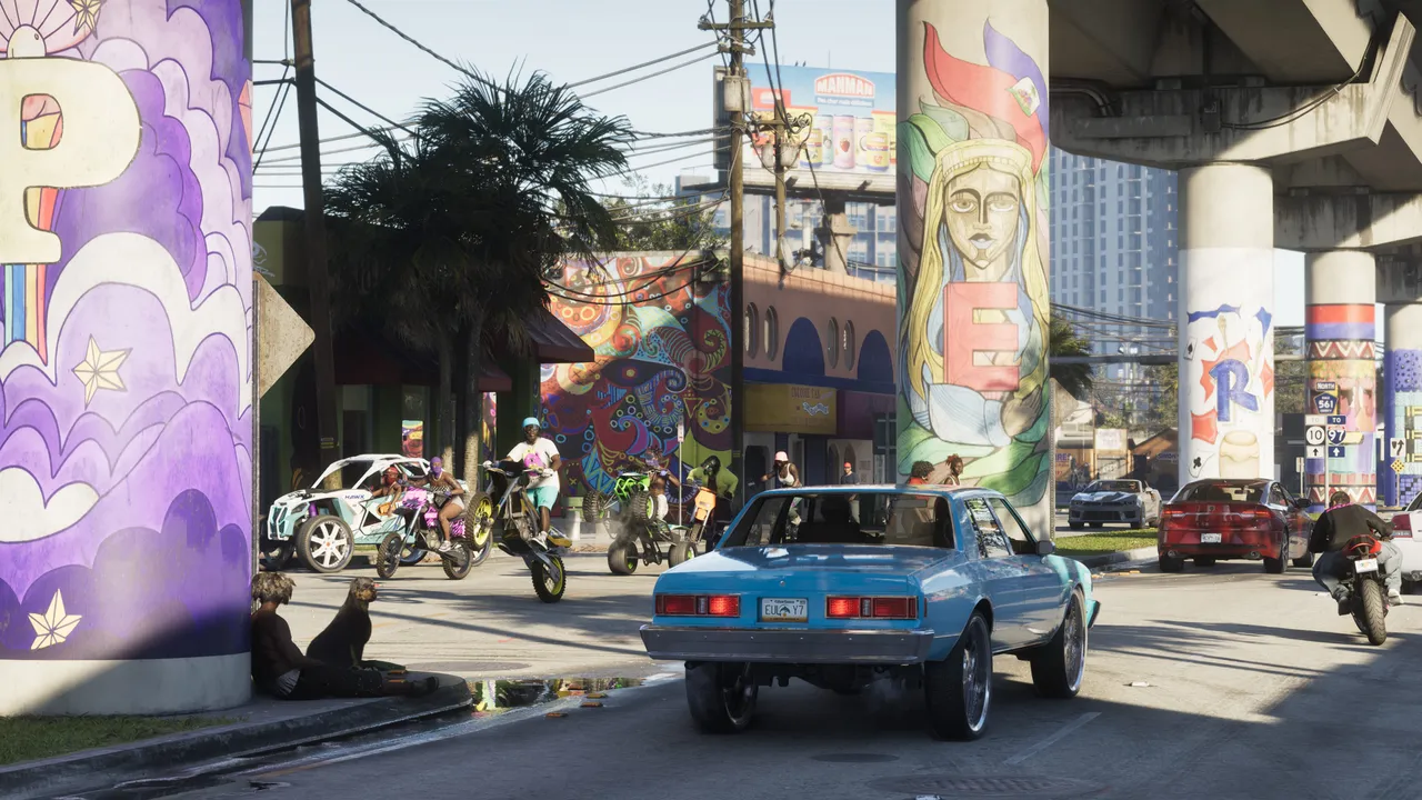 壁画の並ぶVice Cityの大通りを走るクラシックカーとバイクを捉えた公式スクリーンショット