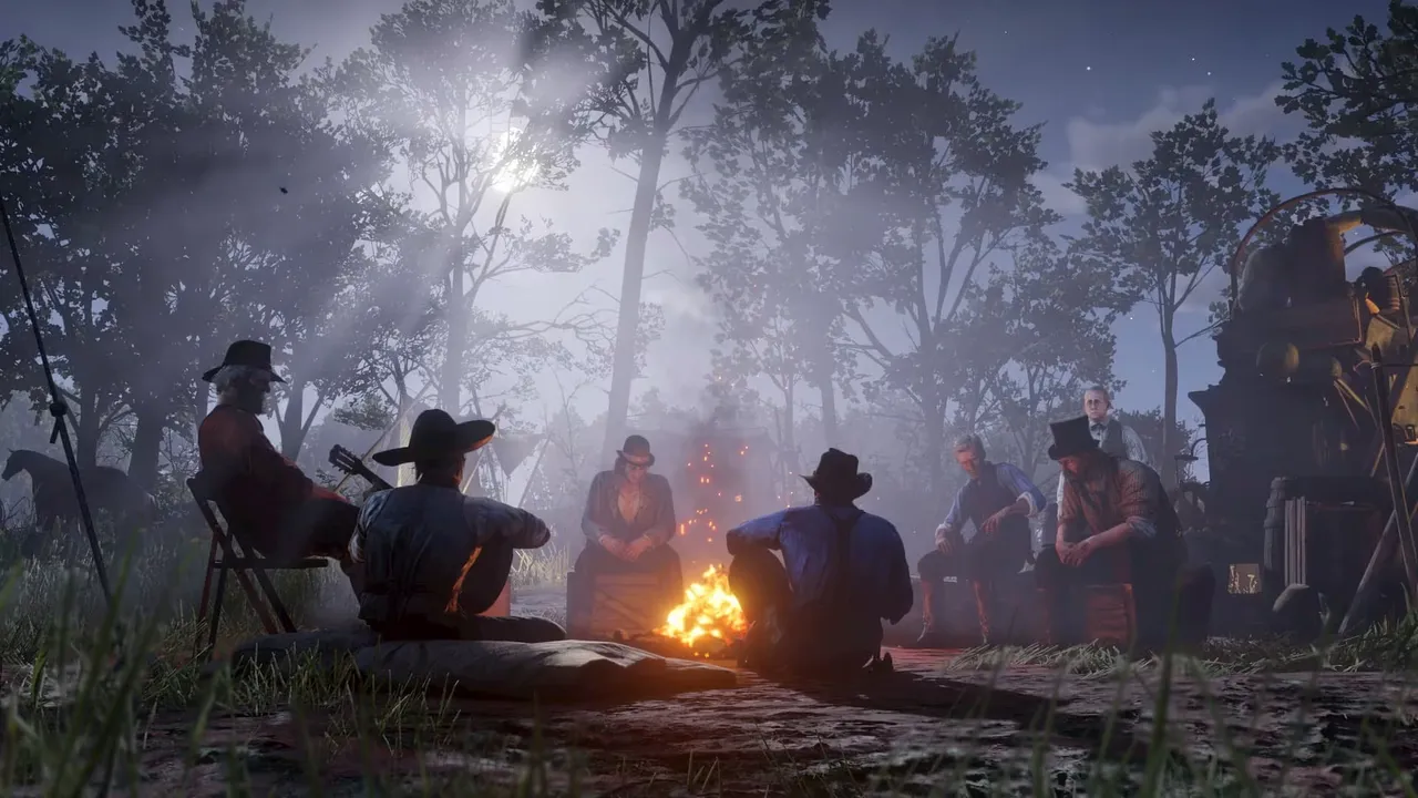 夜の森の中で、たき火を囲んで座る仲間たち。『Red Dead Redemption 2』の公式スクリーンショット